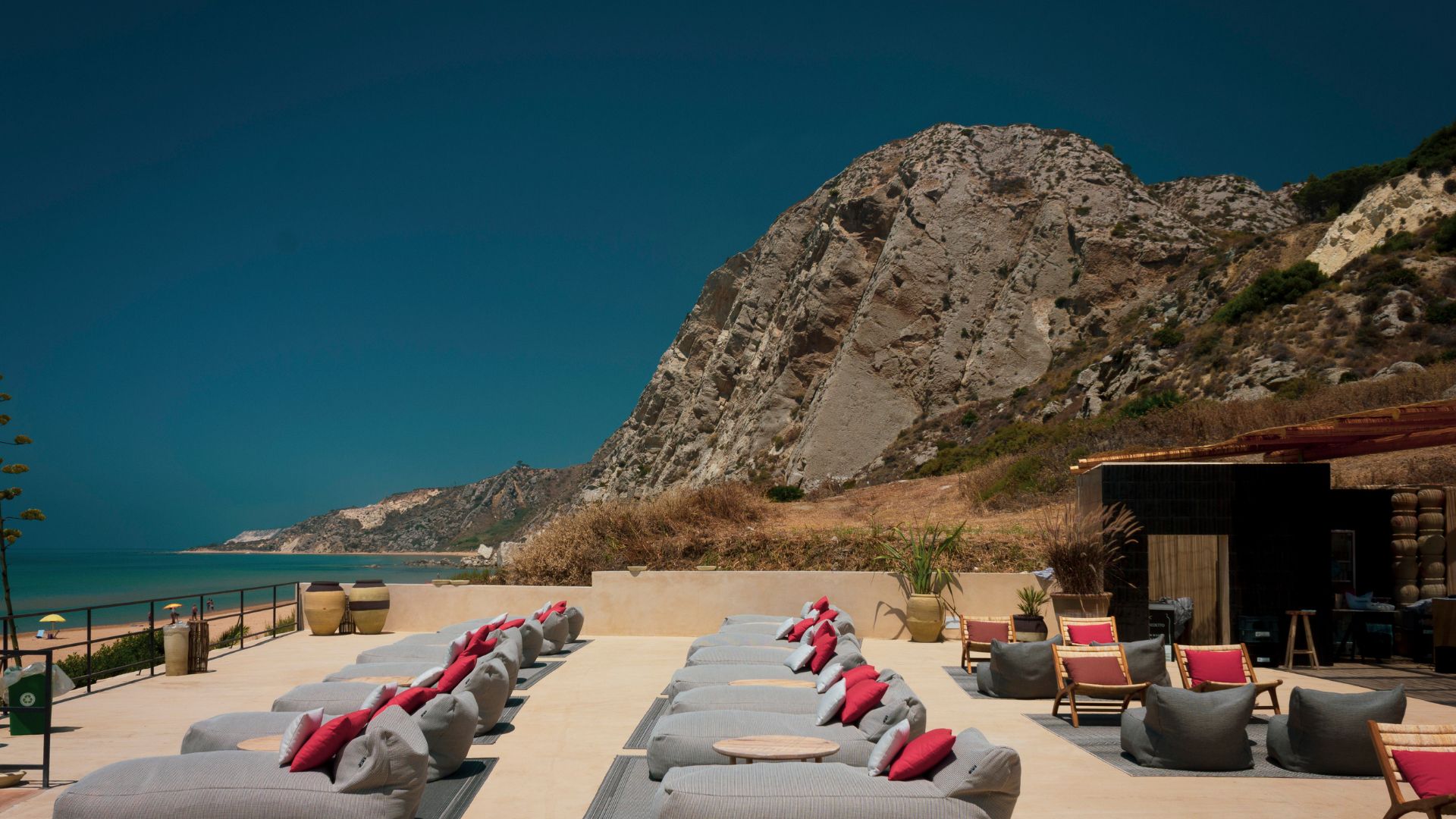 Terrazza sulla spiaggia con lettini vista mare e falesia